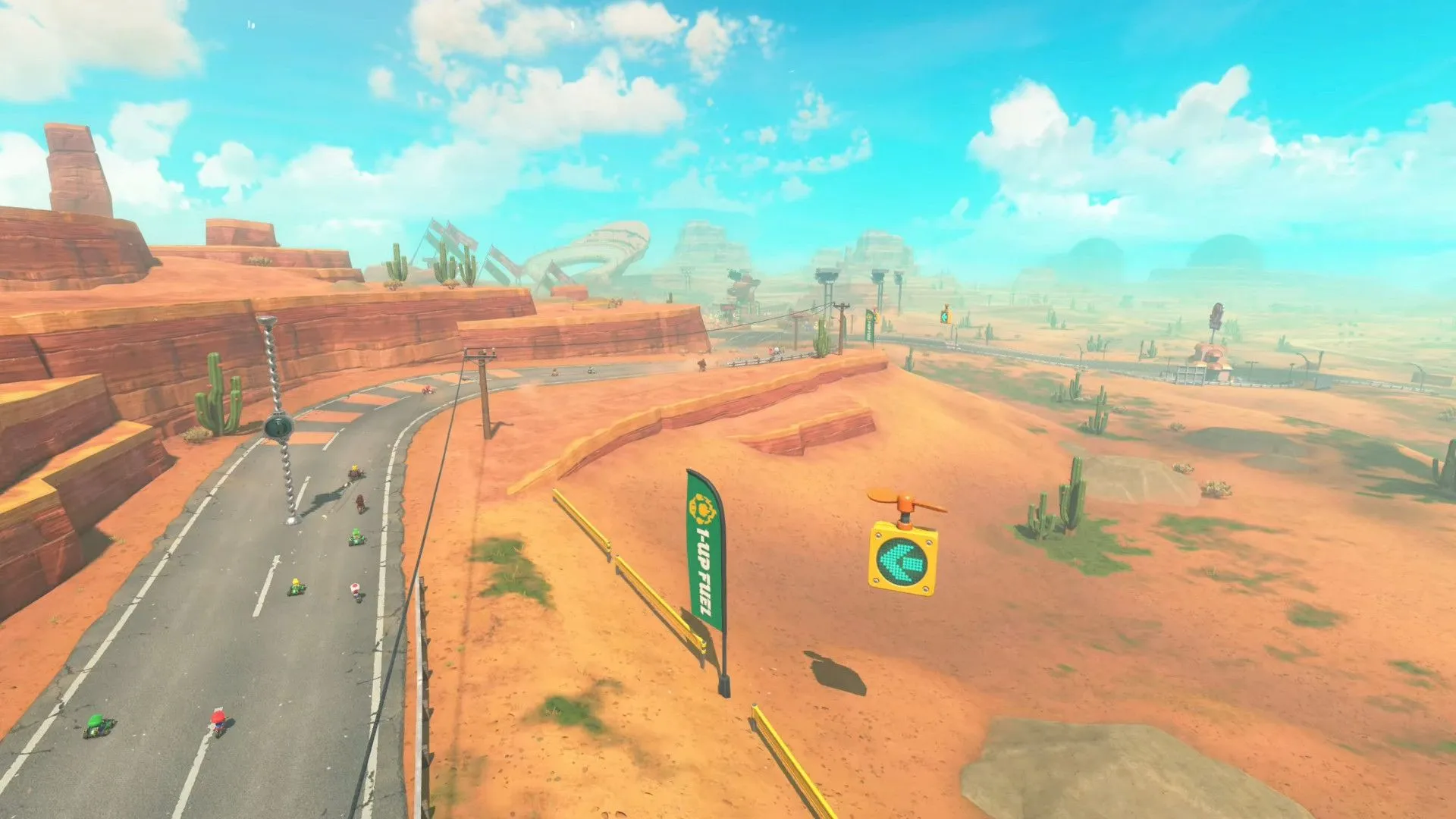 Cảnh quay từ trên cao một đường đua sa mạc trong Mario Kart World, minh họa sự đa dạng về chủ đề môi trường.