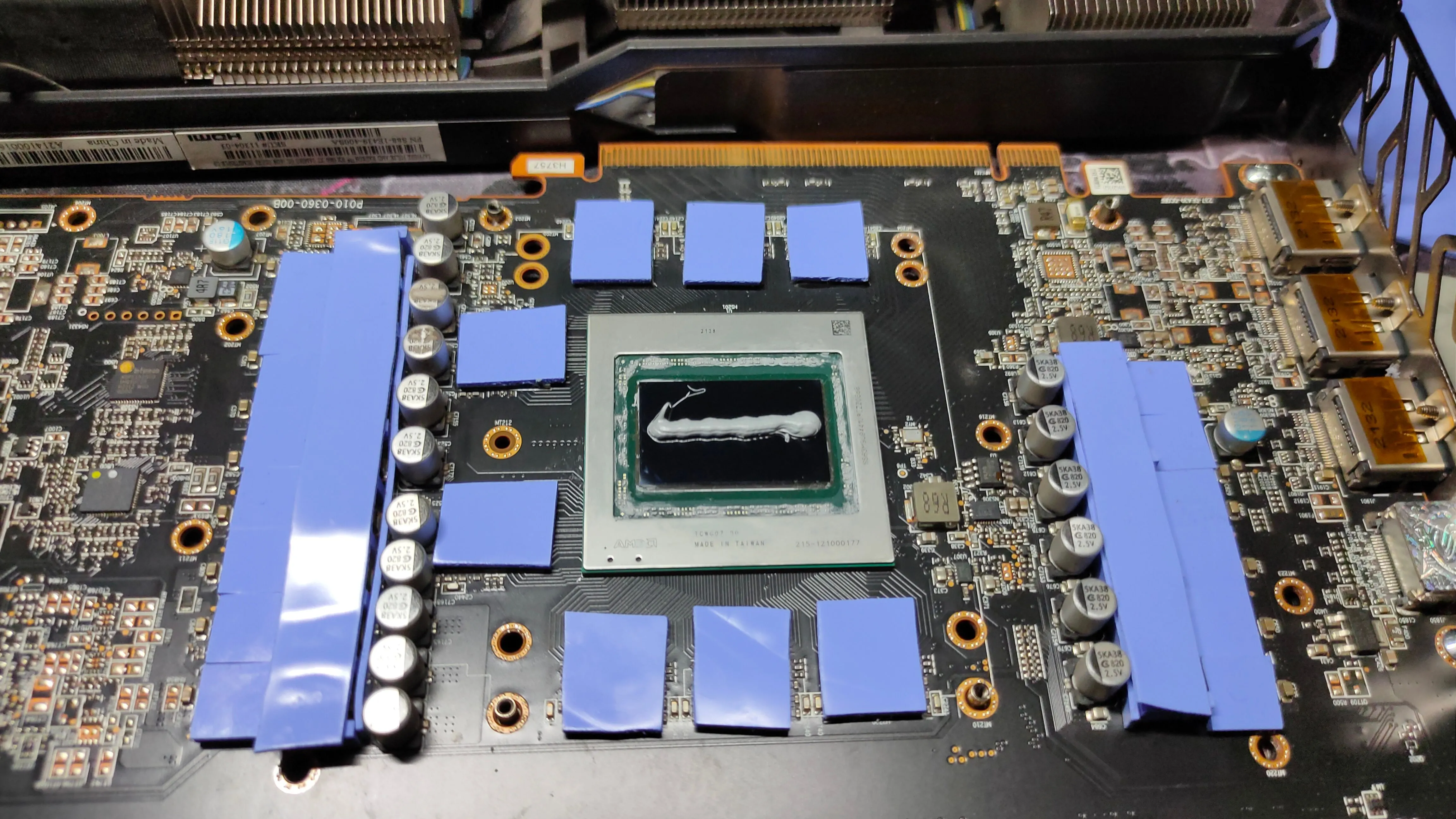 Card đồ họa AMD RX 6800 XT đã được tháo rời, hiển thị các miếng pad nhiệt và keo tản nhiệt mới được thay thế trên PCB.