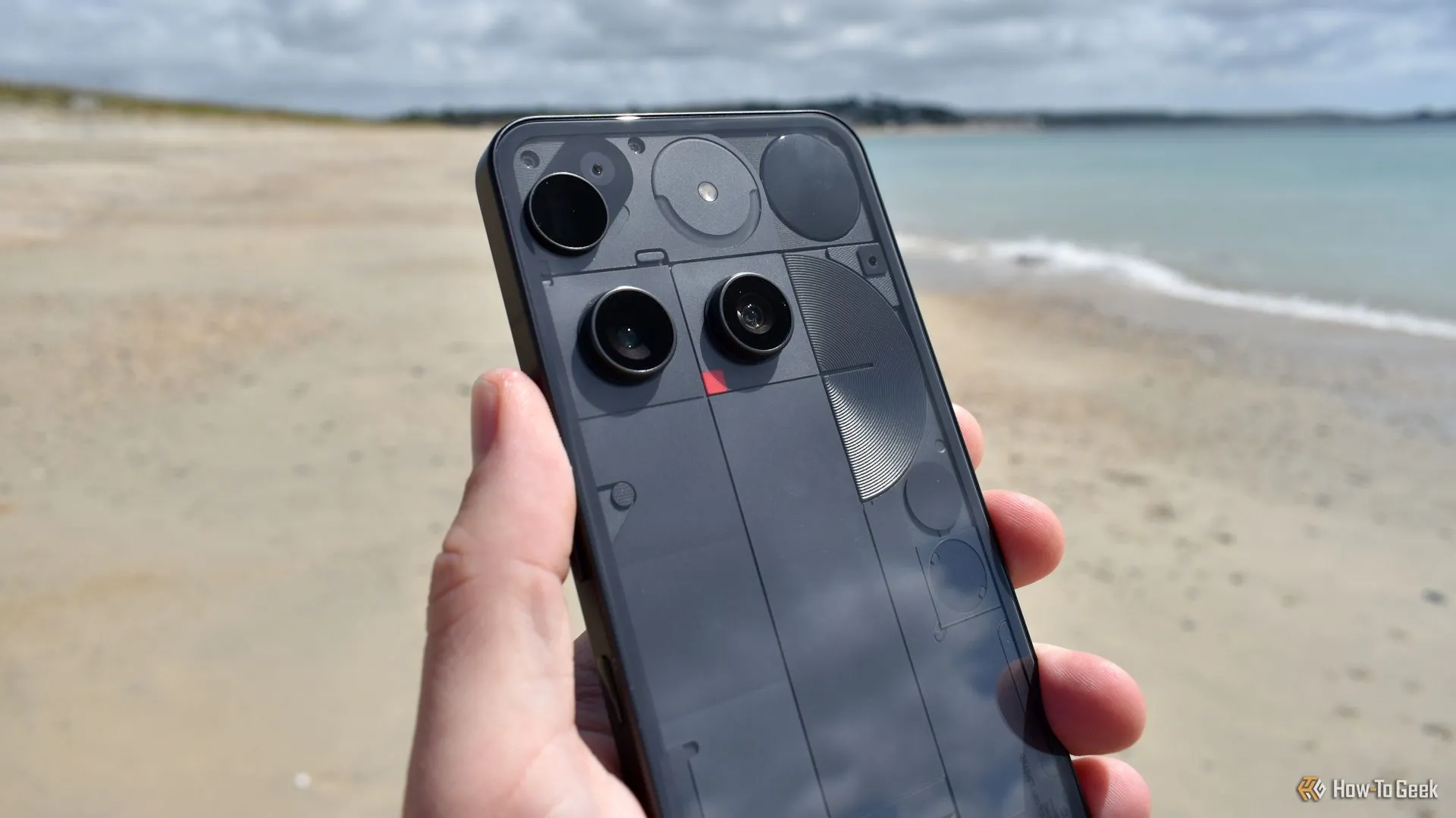 Cụm camera Nothing Phone 3 từ mặt lưng trong bối cảnh bãi biển, cho thấy bố cục và thiết kế của máy