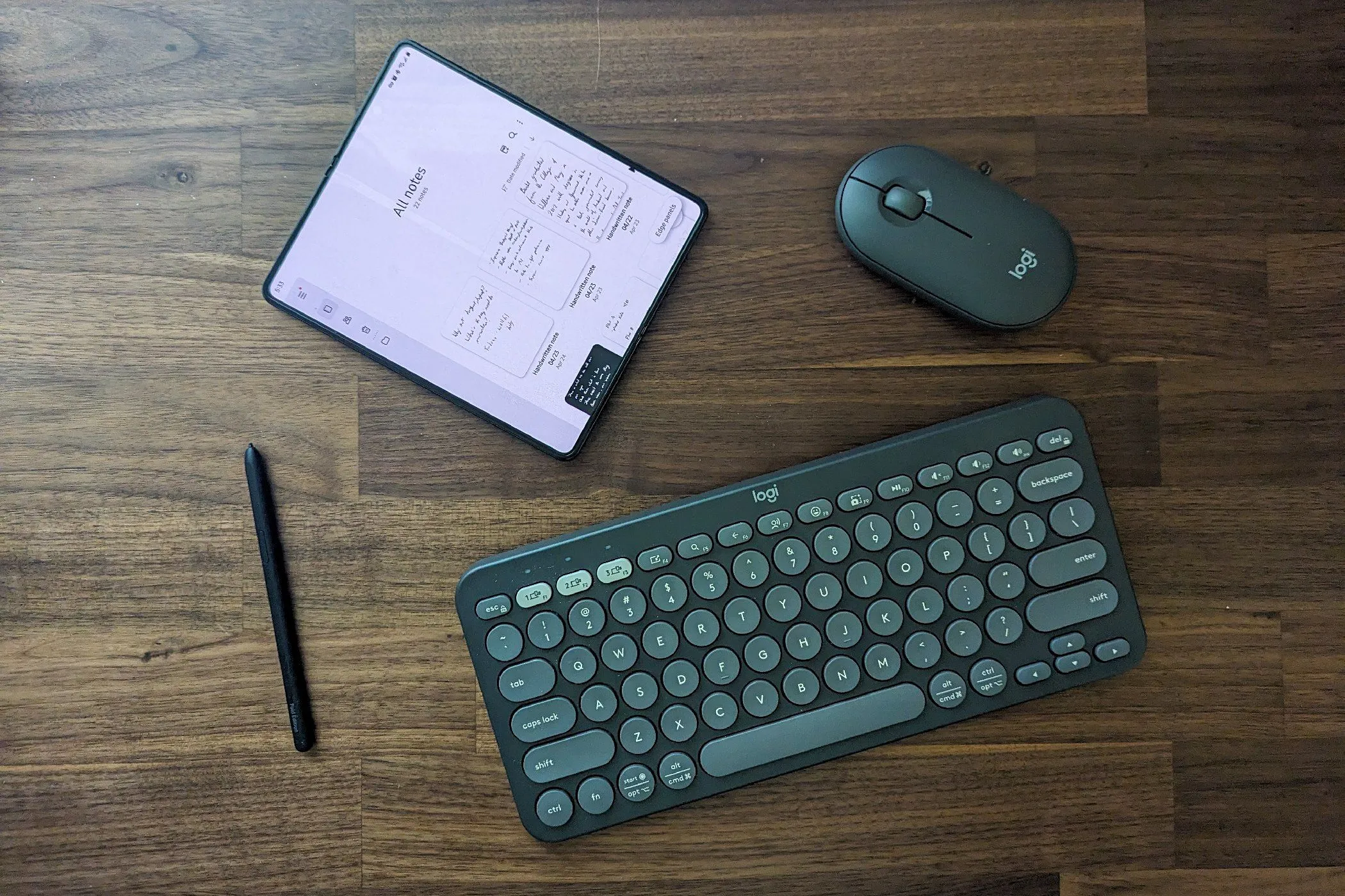 Điện thoại Samsung Galaxy Z Fold 5 cùng các phụ kiện như S Pen và bàn phím Bluetooth, thể hiện khả năng làm việc hiệu quả ngay cả khi không có điện.