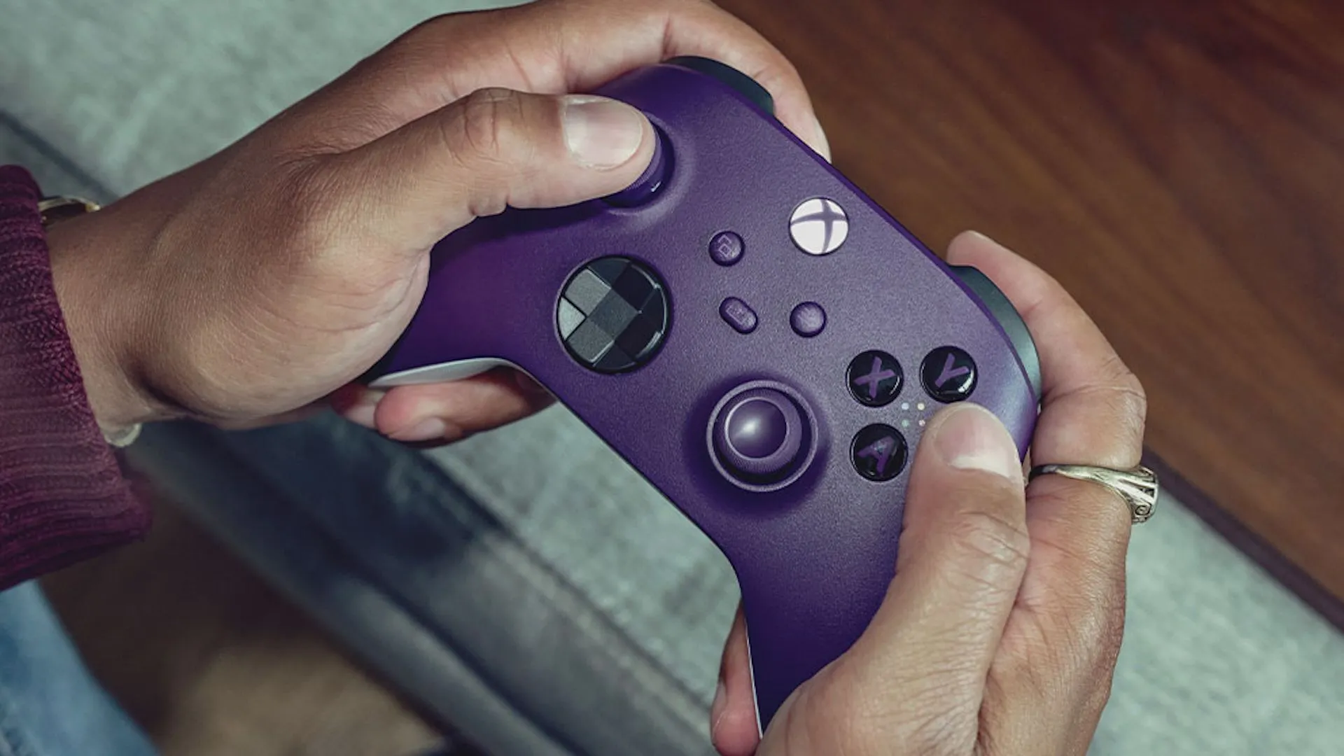 Đôi bàn tay đang cầm bộ điều khiển Xbox Wireless màu tím, minh họa giao diện game quen thuộc