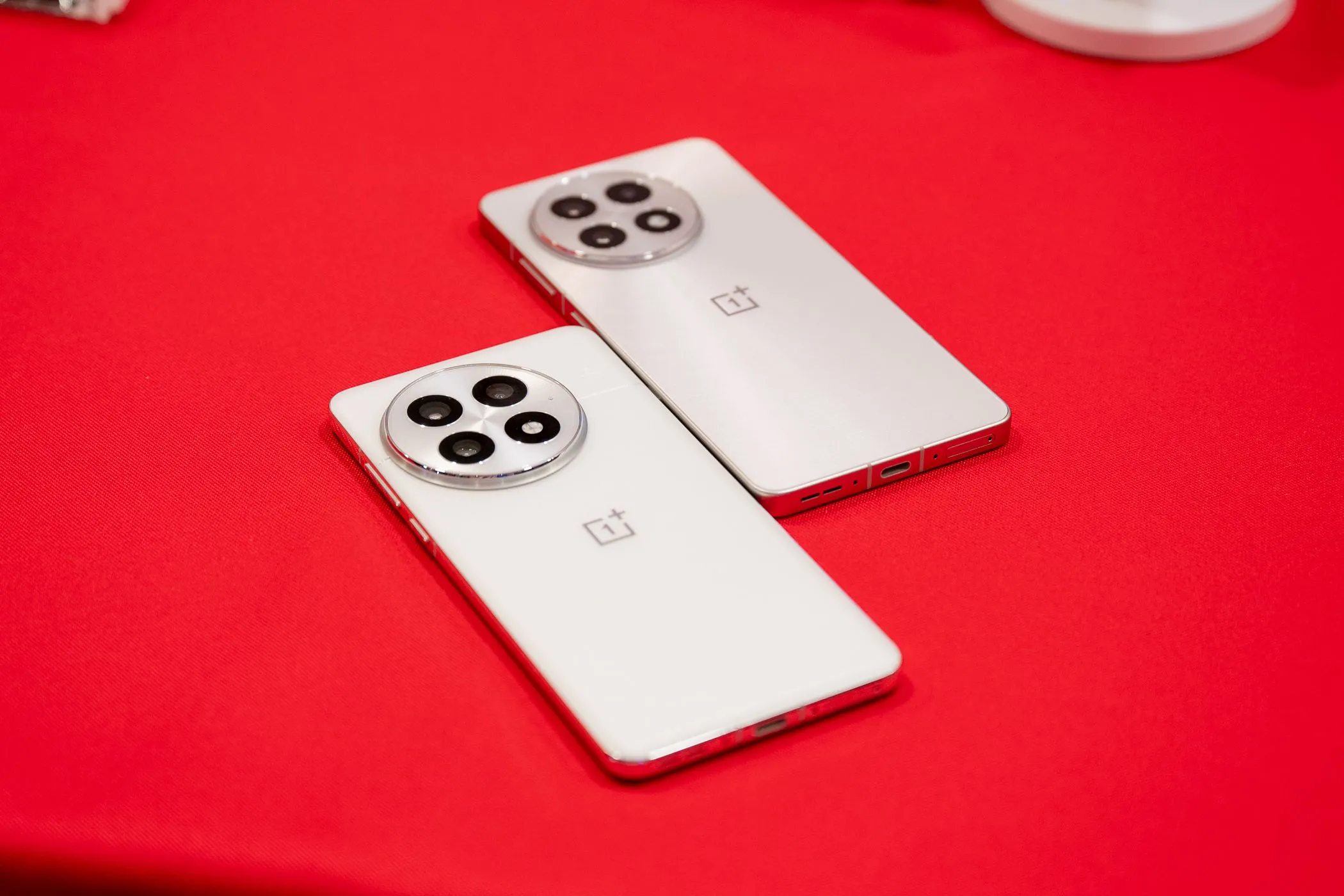 Hai điện thoại OnePlus 13 và OnePlus 13R màu trắng đặt trên bàn, thể hiện thiết kế sang trọng và tần số PWM cao, thân thiện với mắt.