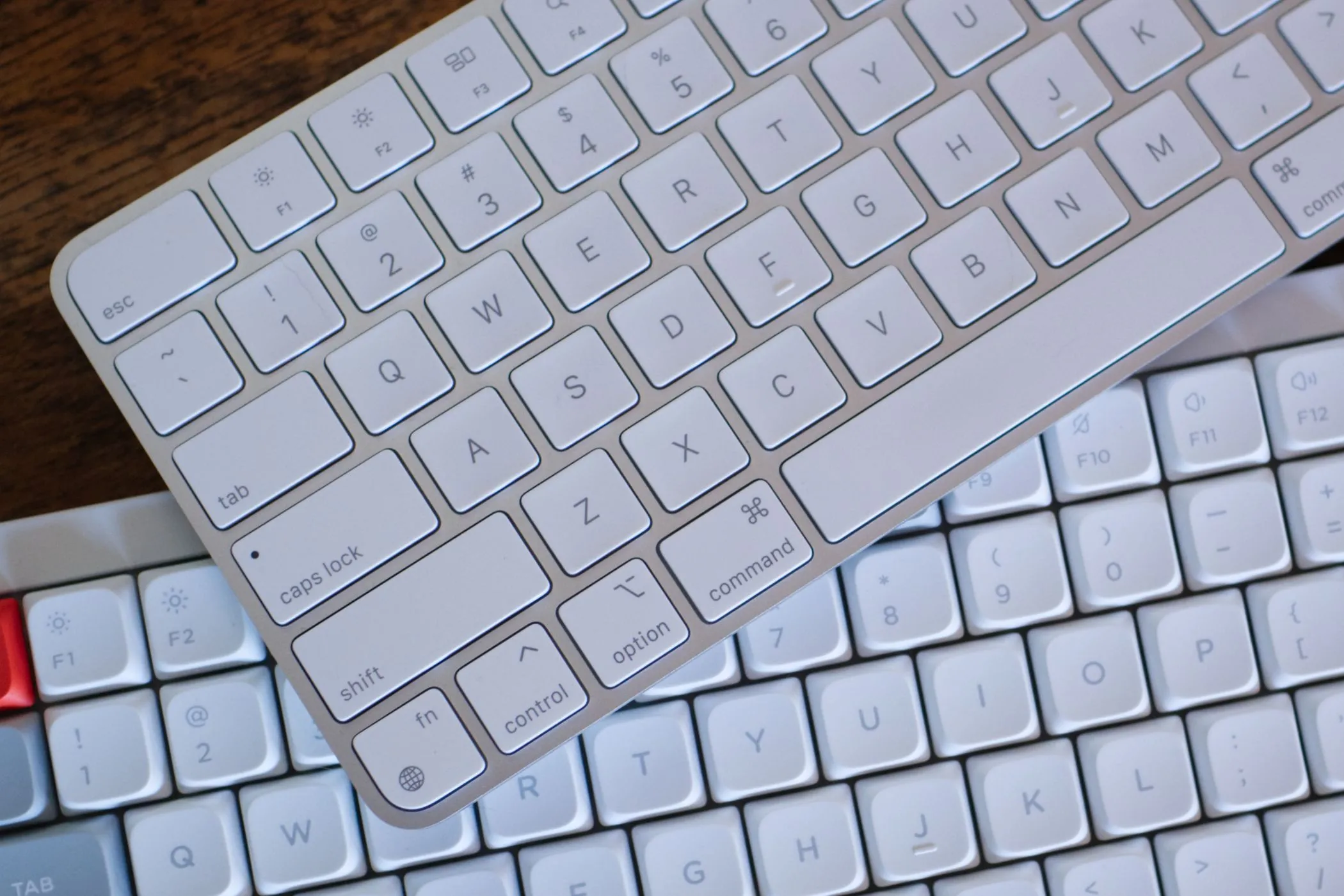 Hai loại bàn phím máy tính: Apple Magic Keyboard và NuPhy Air75, minh họa cho việc sử dụng phím tắt hiệu quả