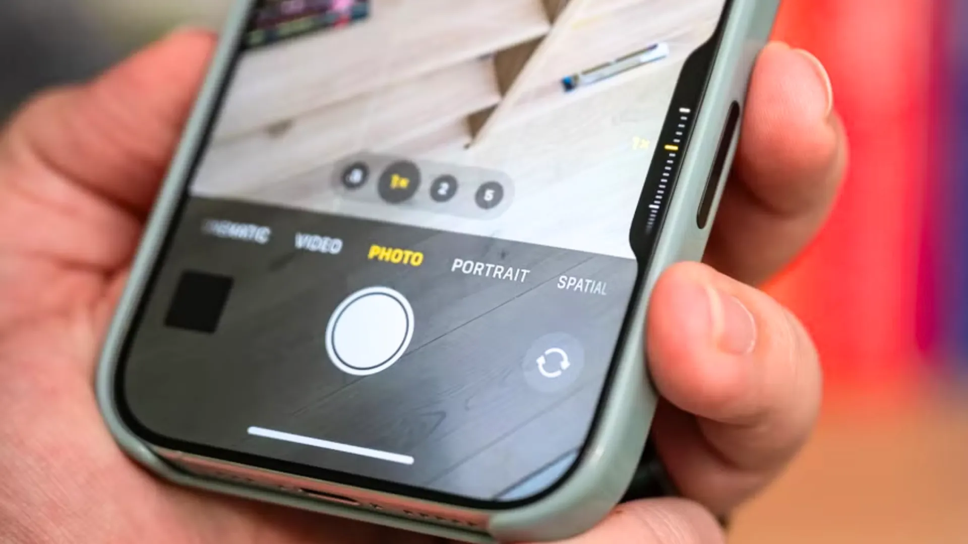 Hình ảnh iPhone 16 Plus được cầm trên tay với nút Camera Control ở góc trên bên phải.