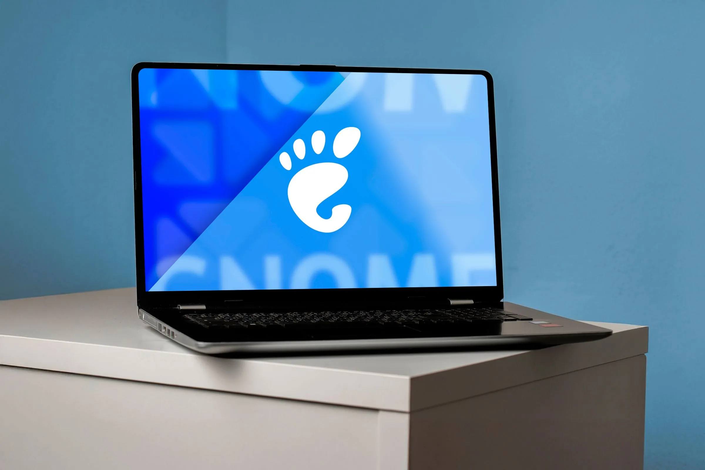 Màn hình máy tính xách tay hiển thị logo GNOME lớn, biểu tượng của môi trường desktop GNOME 48.