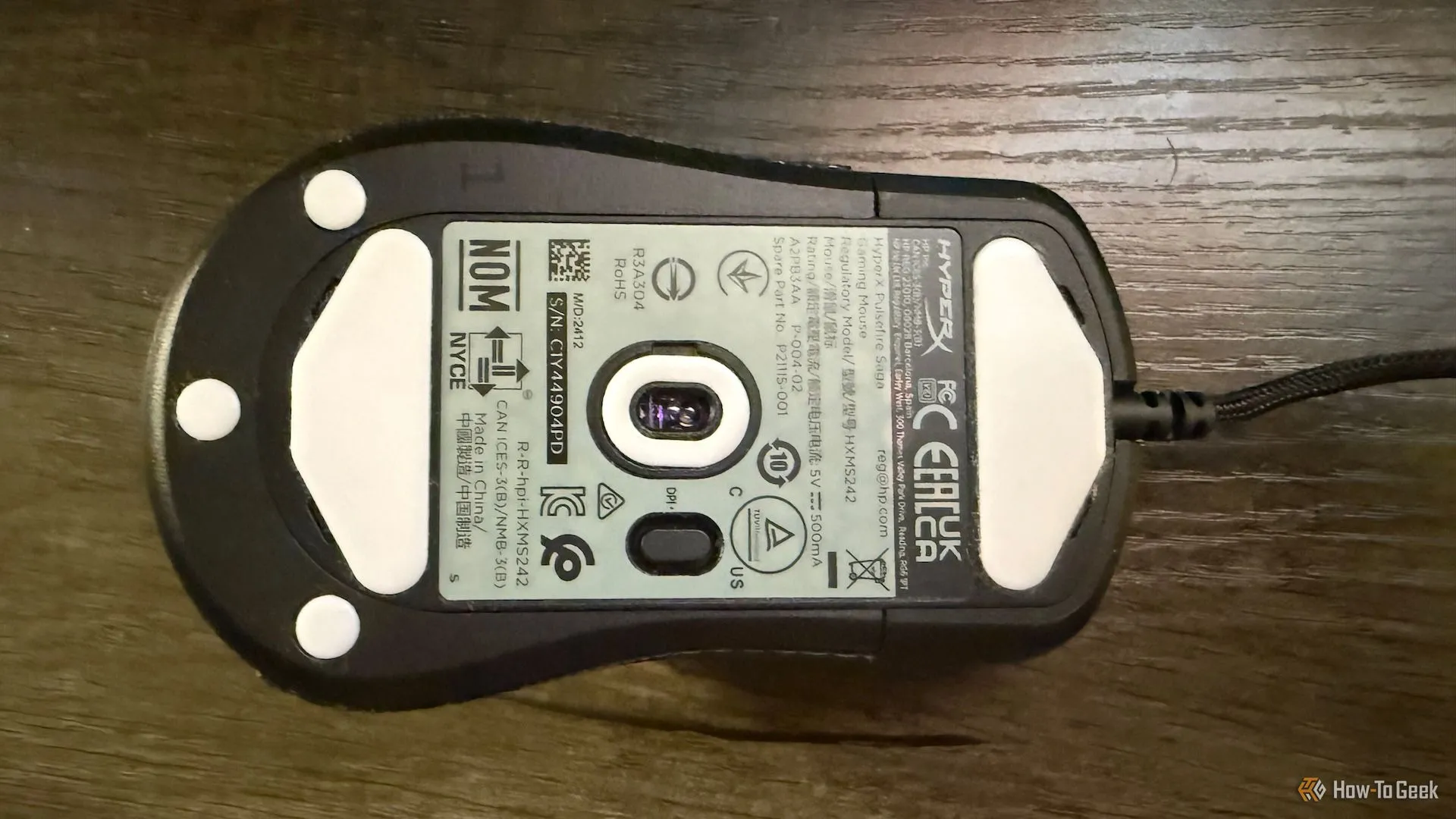 Mặt dưới chuột HyperX Pulsefire Saga hiển thị các feet trượt và cảm biến quang học