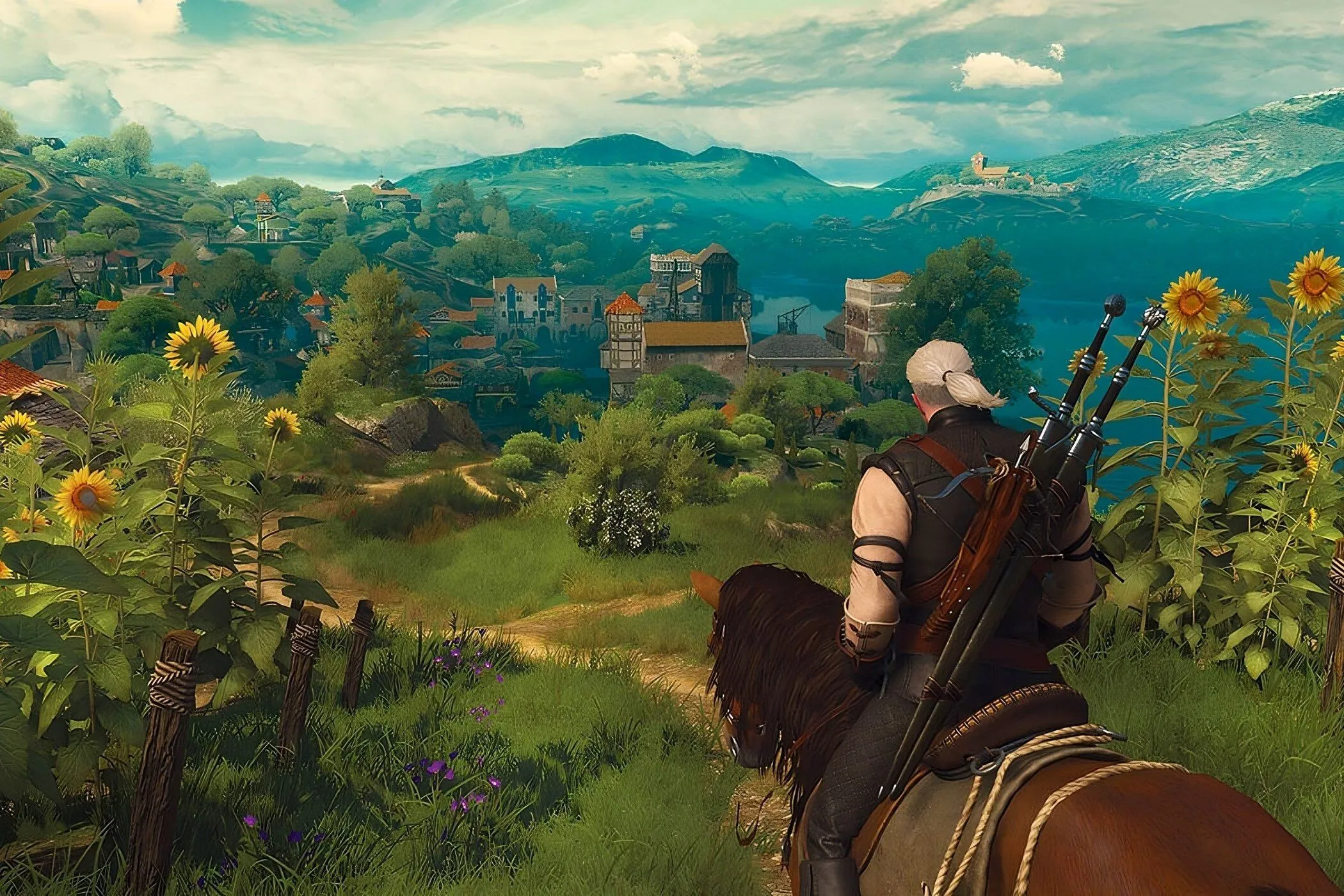 Một khung cảnh quảng cáo từ The Witcher 3, với nhân vật chính Geralt và hai nữ nhân vật Yennefer và Ciri đứng trên một địa điểm đẹp