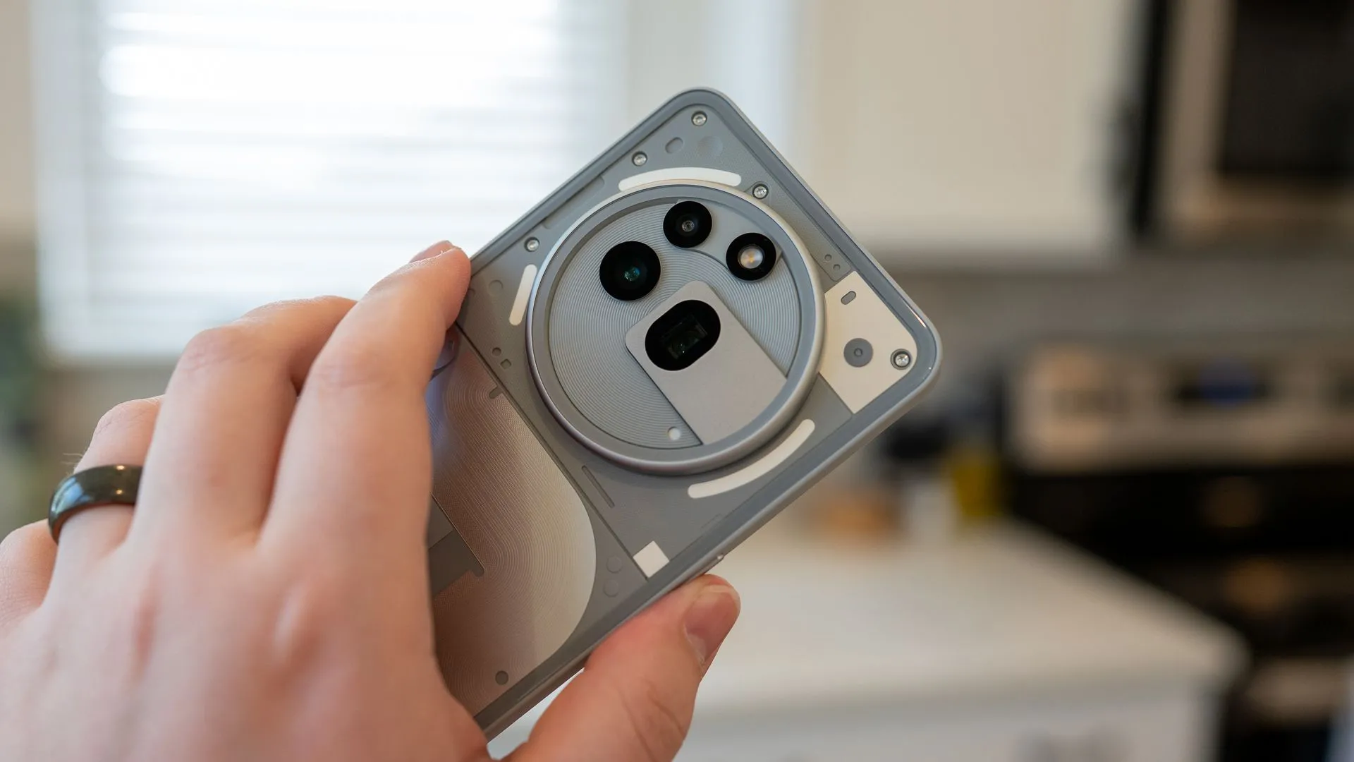 Một người cầm điện thoại Nothing Phone (3a) Pro tập trung vào cụm camera sau.