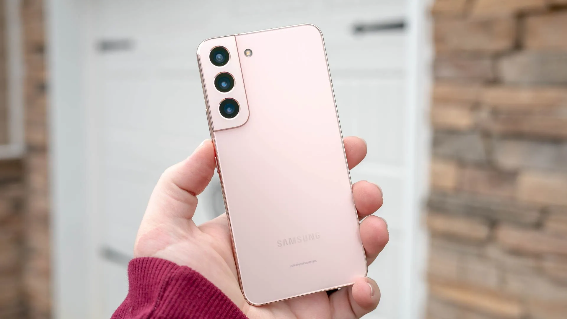 Một người cầm điện thoại thông minh Galaxy S22.