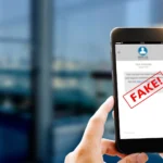 Người đàn ông cầm điện thoại hiển thị tin nhắn lừa đảo "Tôi đổi số rồi"