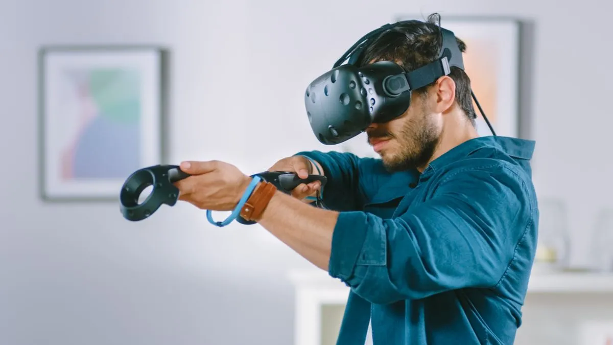 Người đàn ông đeo tai nghe VR và điều khiển bằng bộ điều khiển cầm tay
