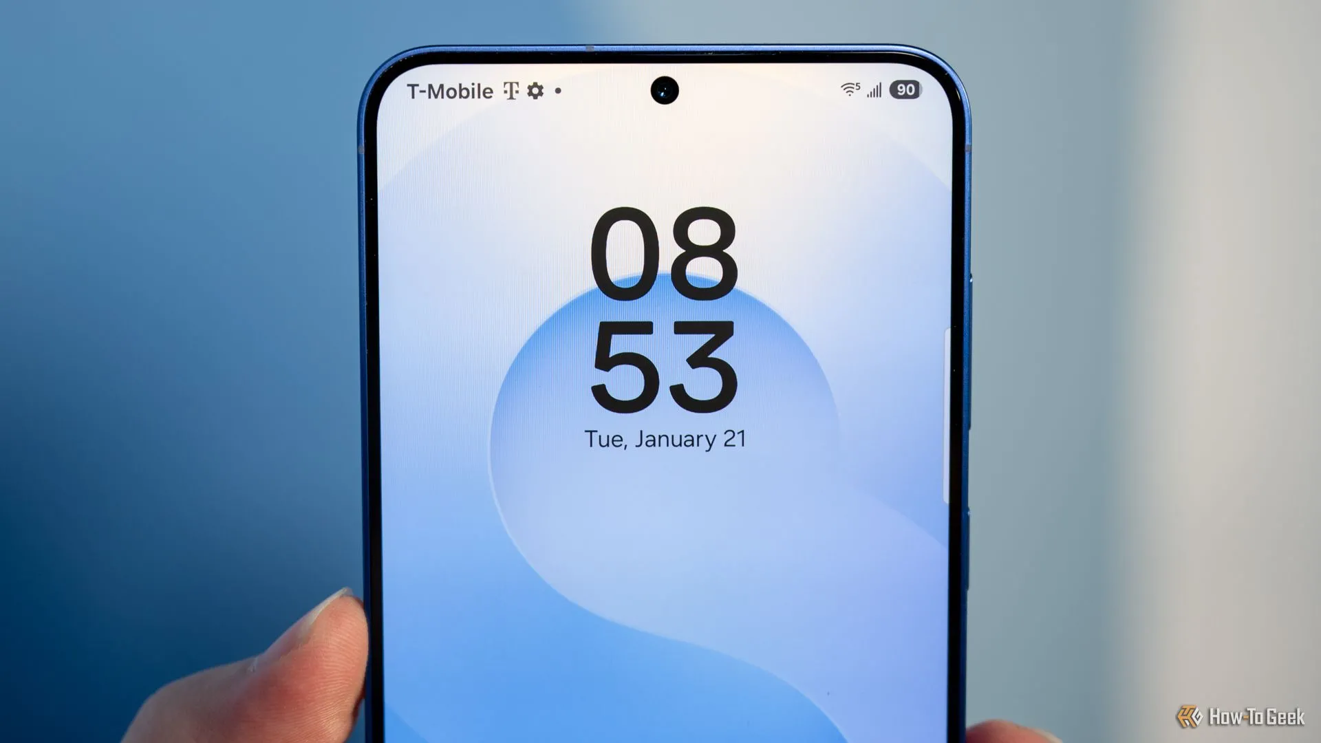 Người đang cầm Samsung Galaxy S25+ nhìn vào camera trước và viền màn hình.
