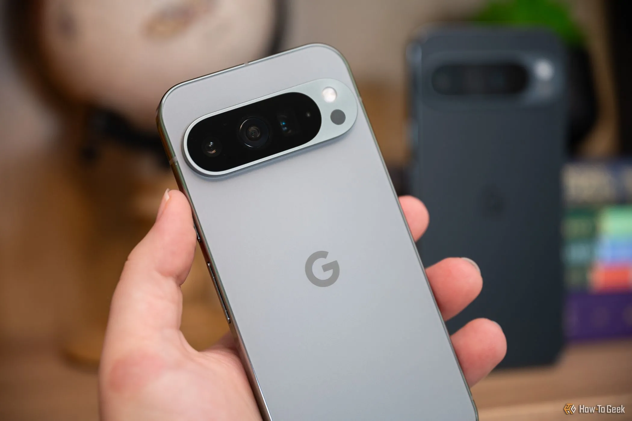 Người dùng cầm điện thoại Google Pixel 9 Pro hiển thị cạnh chiếc 9 Pro XL, minh họa sự khác biệt kích thước giữa hai mẫu.