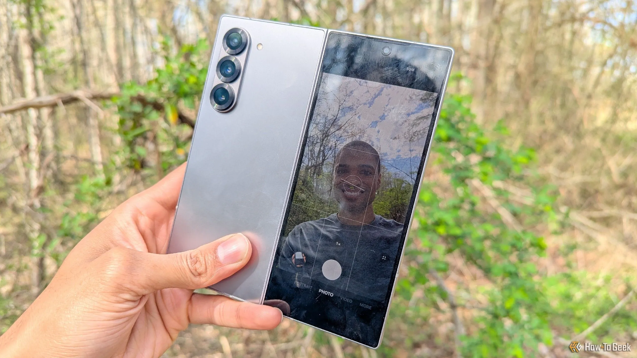 Người dùng đang chụp ảnh selfie bằng camera sau của Galaxy Z Fold 6, tận dụng màn hình ngoài làm kính ngắm để có ảnh chất lượng cao.