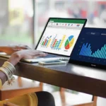 Người phụ nữ làm việc trên laptop và màn hình rời, minh họa việc quản lý dự án cá nhân tại nơi làm việc.