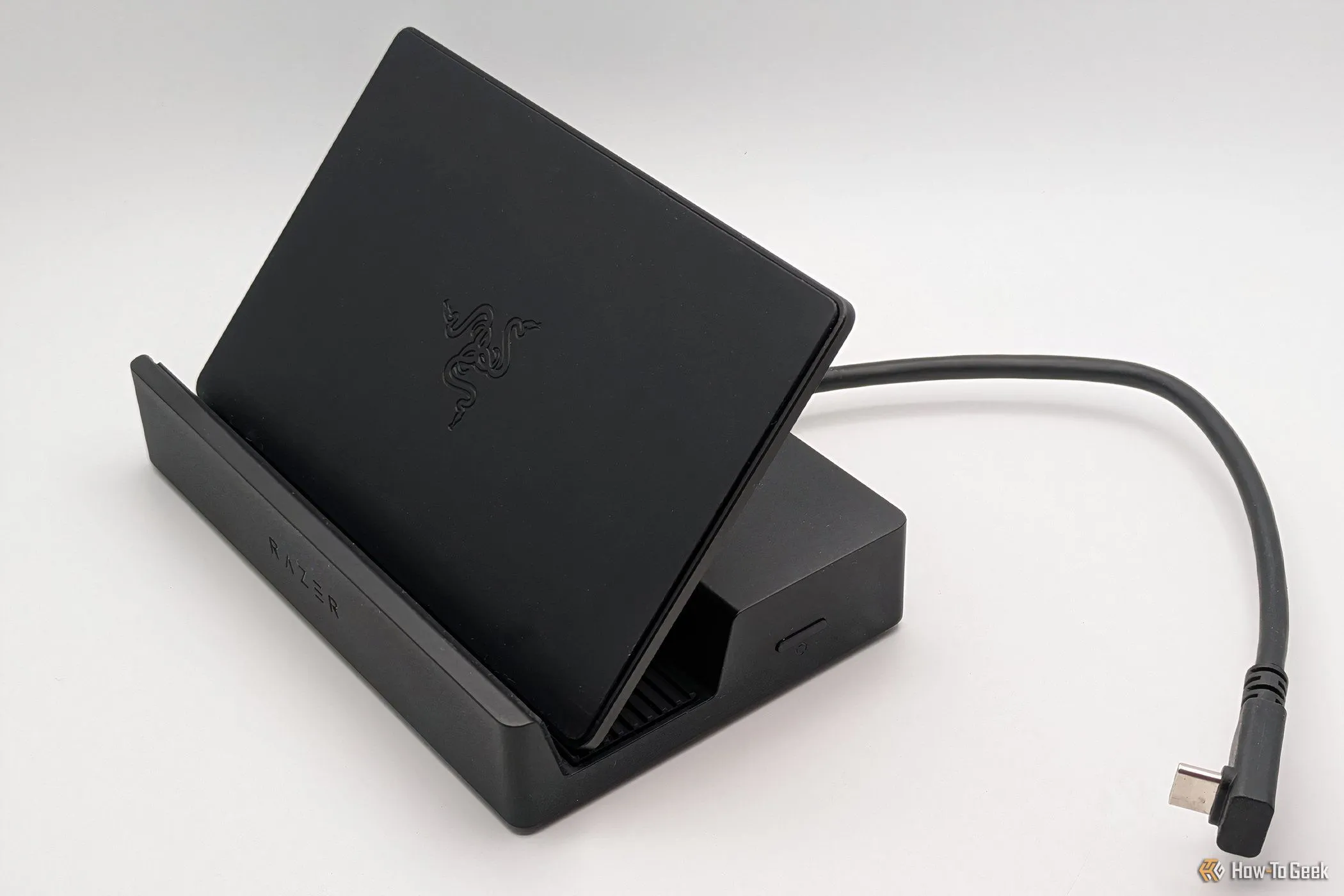 Razer Handheld Dock Chroma với chân đế dựng thẳng, hiển thị rõ cổng USB-C và khả năng giữ thiết bị chơi game cầm tay