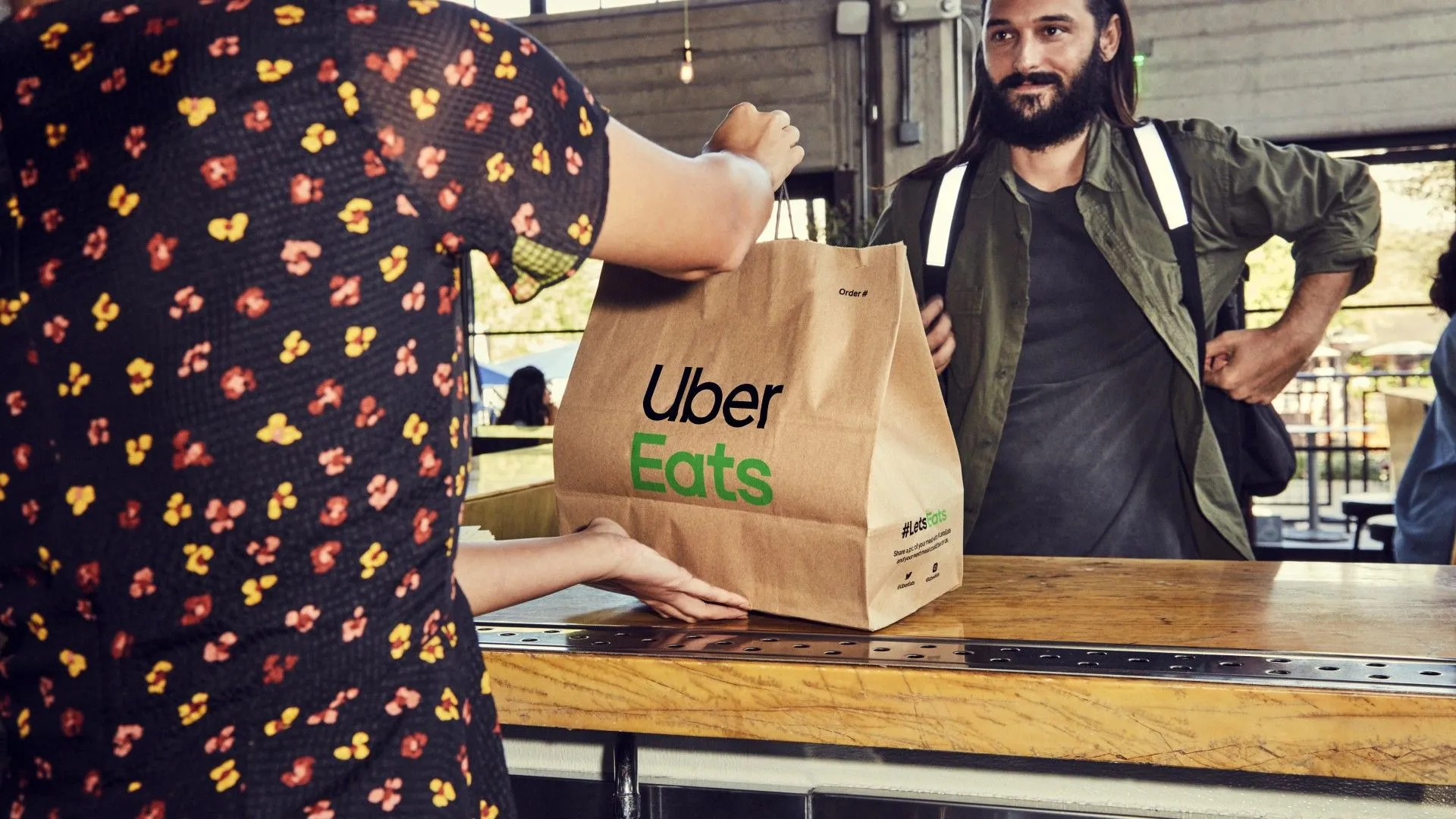 Tài xế Uber Eats nhận đơn hàng đồ ăn từ nhà hàng để giao, minh họa cách kiếm tiền linh hoạt