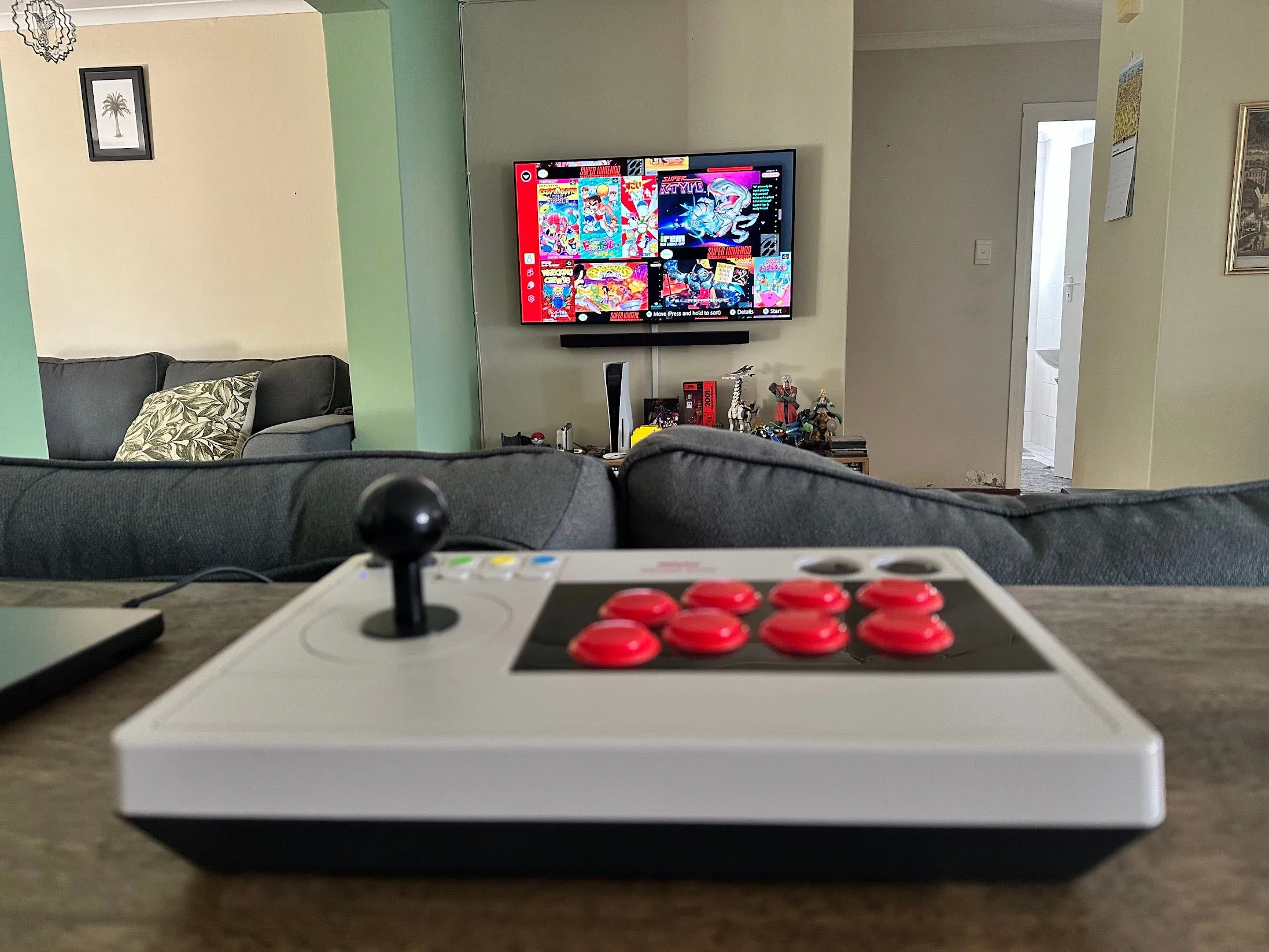 Tay cầm đối kháng 8BitDo phong cách arcade cùng màn hình hiển thị các tựa game SNES cổ điển, gợi nhớ trải nghiệm game thùng.