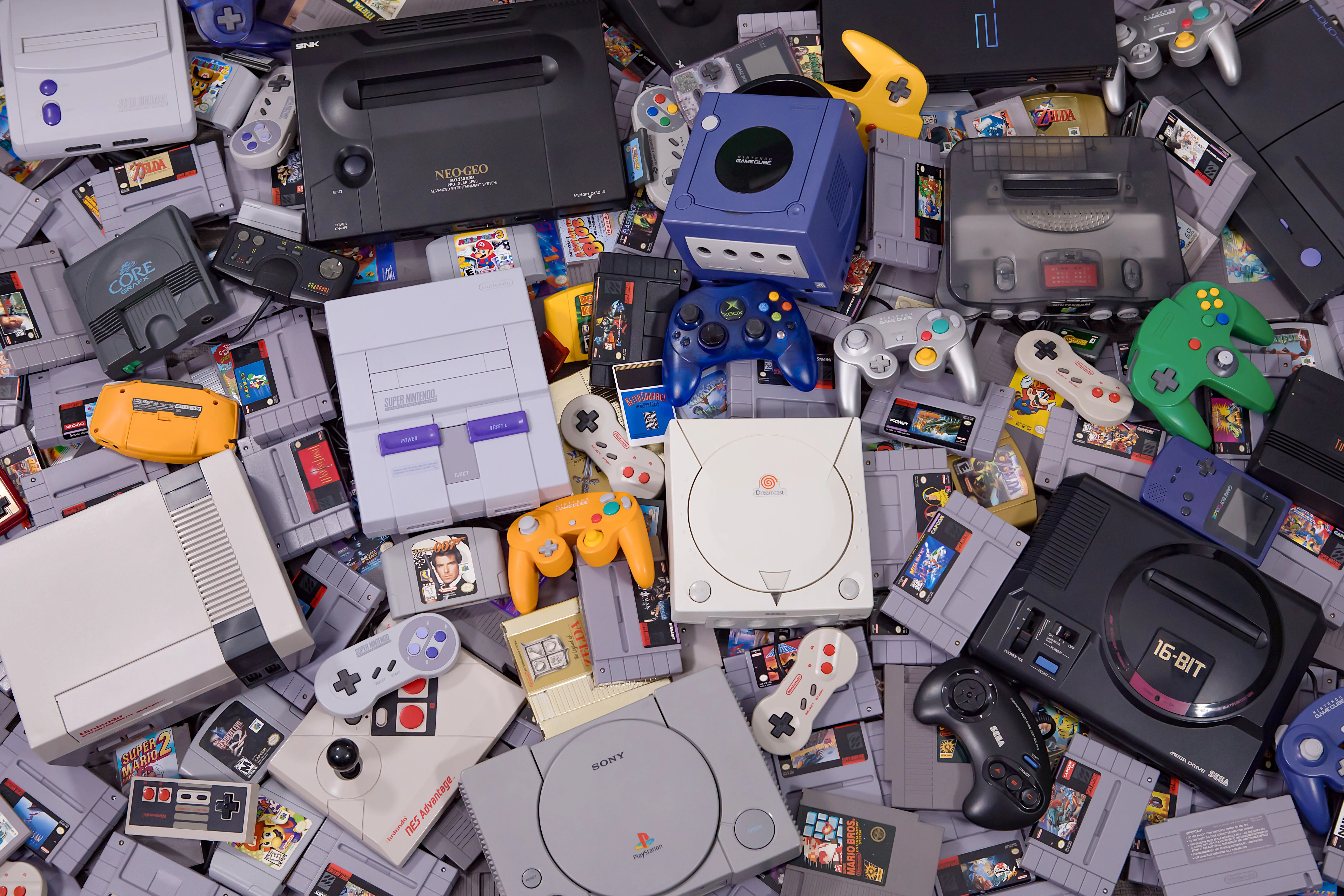 Tổng hợp các hệ máy console, tay cầm và băng game retro cổ điển chụp từ trên cao.