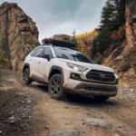 Toyota RAV4 Hybrid 2024 màu trắng đang di chuyển off-road, minh họa sự đa dụng và tính phổ biến của mẫu SUV cỡ nhỏ.