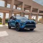 Toyota RAV4 Hybrid 2024 màu xanh lam đỗ trên vỉa hè, mẫu xe đang gặp thách thức về nguồn cung linh kiện hybrid.