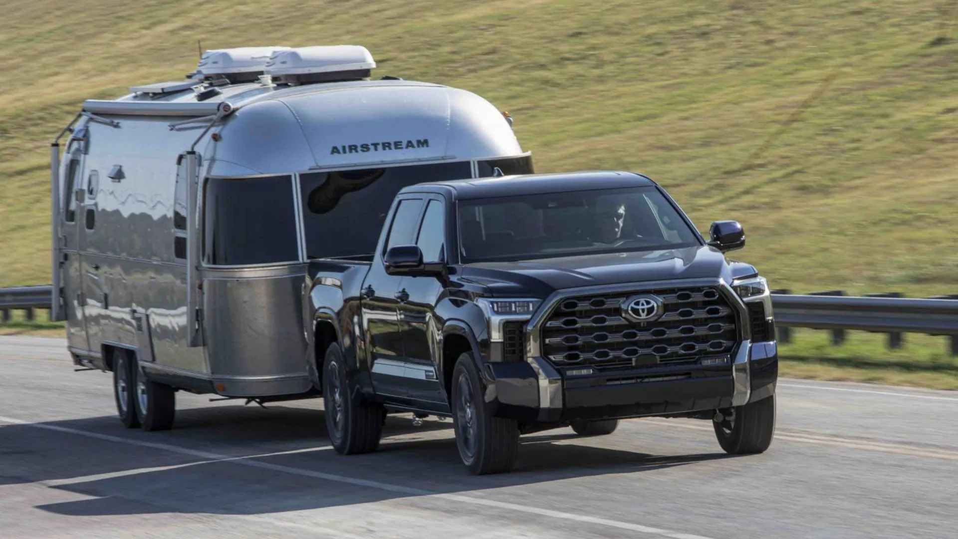 Toyota Tundra Platinum Blueprint 2025 kéo rơ-moóc trên đường nông thôn, minh họa một trong những mẫu xe Tundra bị ảnh hưởng lỗi đèn lùi.
